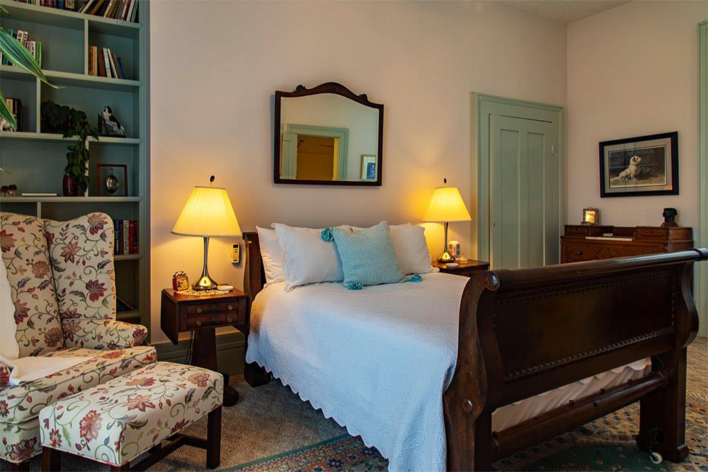 Fitzarran Library room, Beautiful queen size bed with white linens and floral reading chair